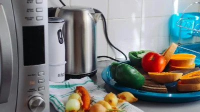 Modern energy-efficient kitchen with induction cooktop, convection oven, and slow cooker on counter.