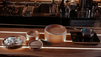 A pot of food cooking on a stove with lid on next to a pot with lid off, illustrating energy efficiency.