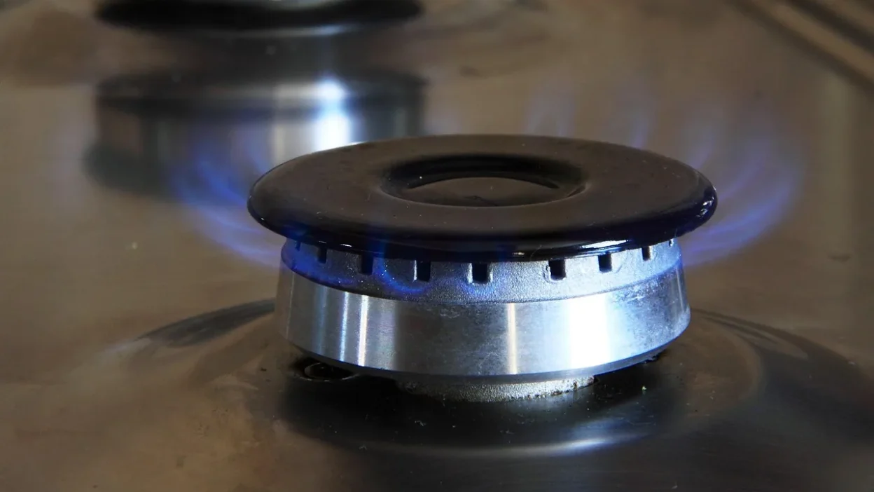 Stovetop efficiency checklist infographic showing burner size matching, lid use, and cooking timing tips.