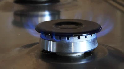 Stovetop efficiency checklist infographic showing burner size matching, lid use, and cooking timing tips.