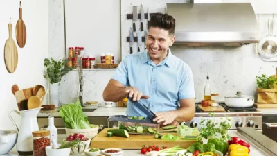 A home cook efficiently preps vegetables and organizes ingredients on a kitchen counter to save time.